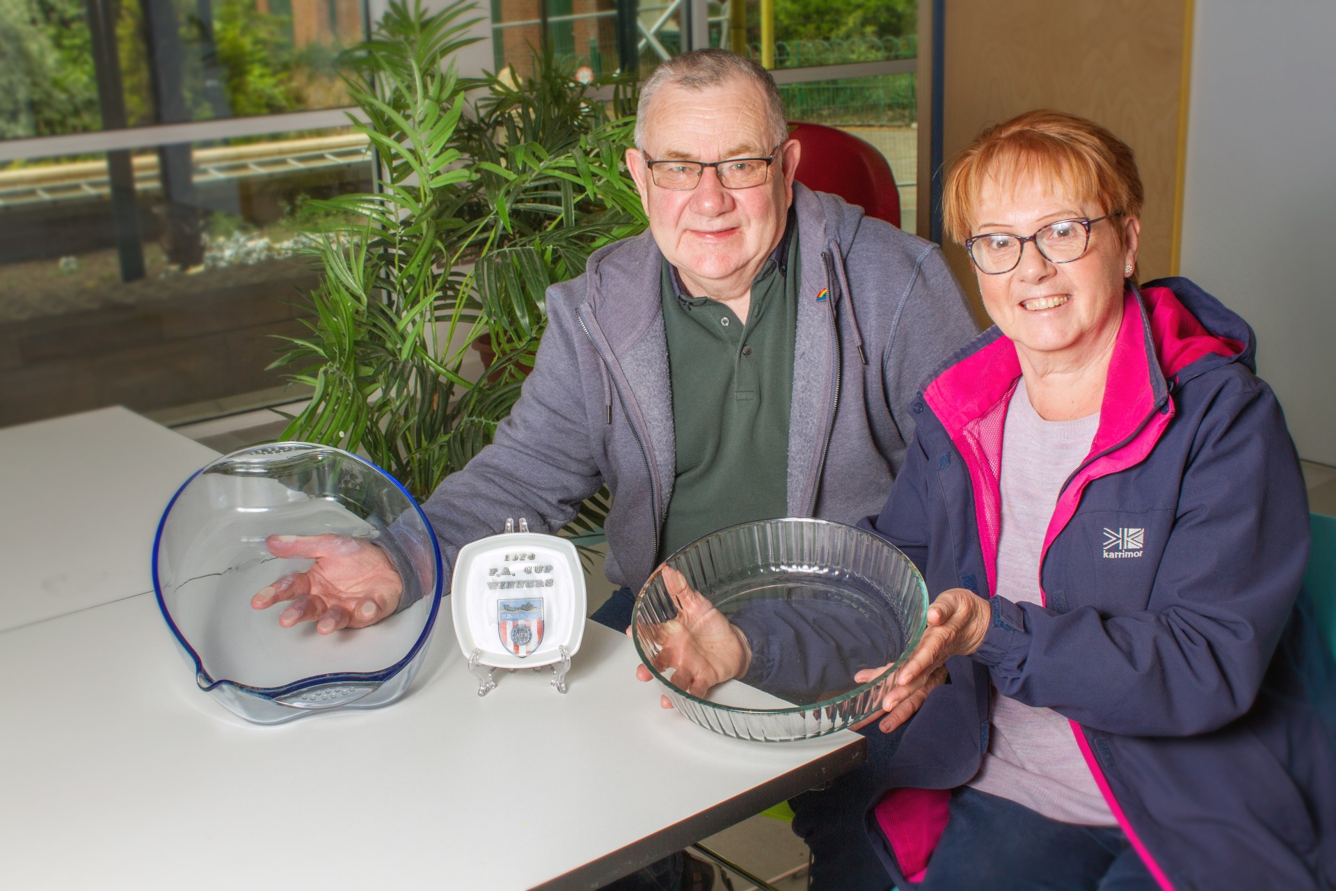 Carole and her husband with ‘Pyrex’ roasting dish, FA cup winners commemorative plate and fluted pie dish Logo